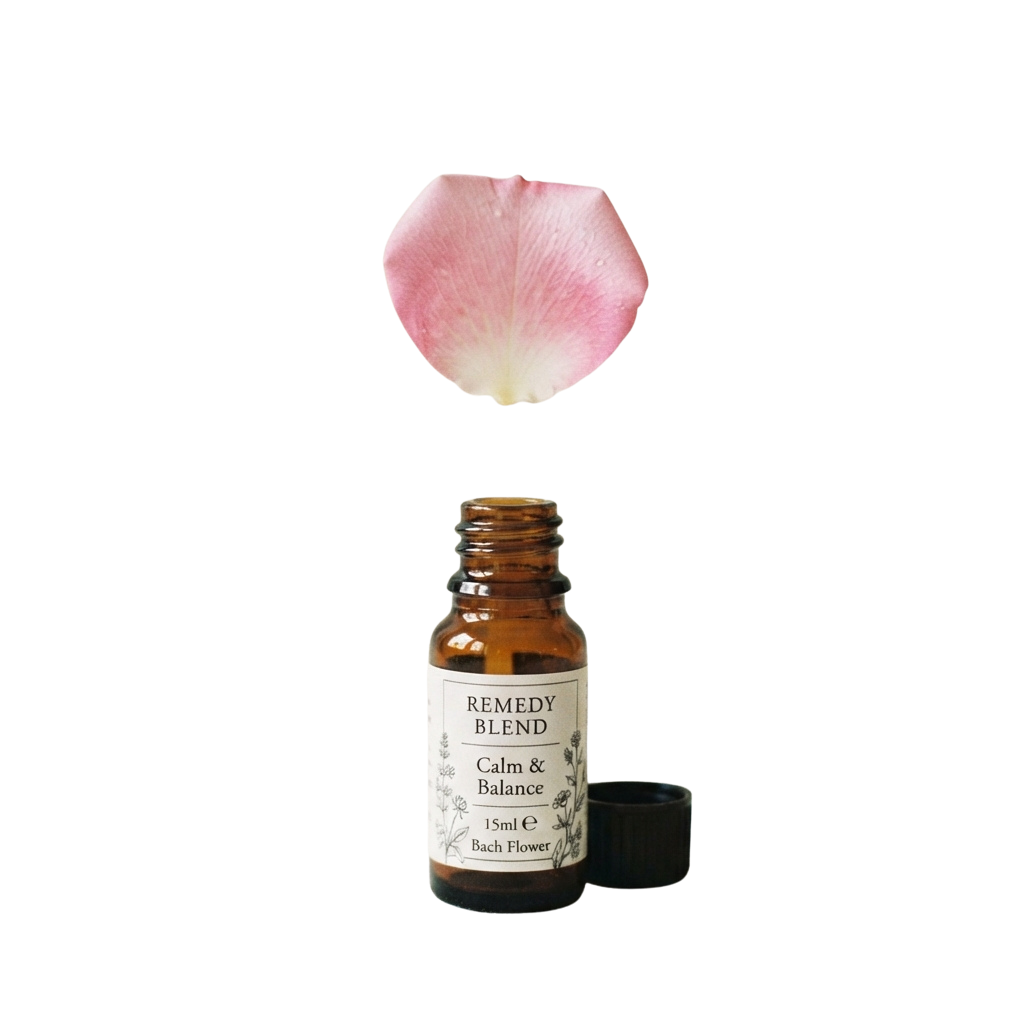Small bottle of Bach Flower Remedy Blend labeled Calm and Balance with a pink flower petal above it