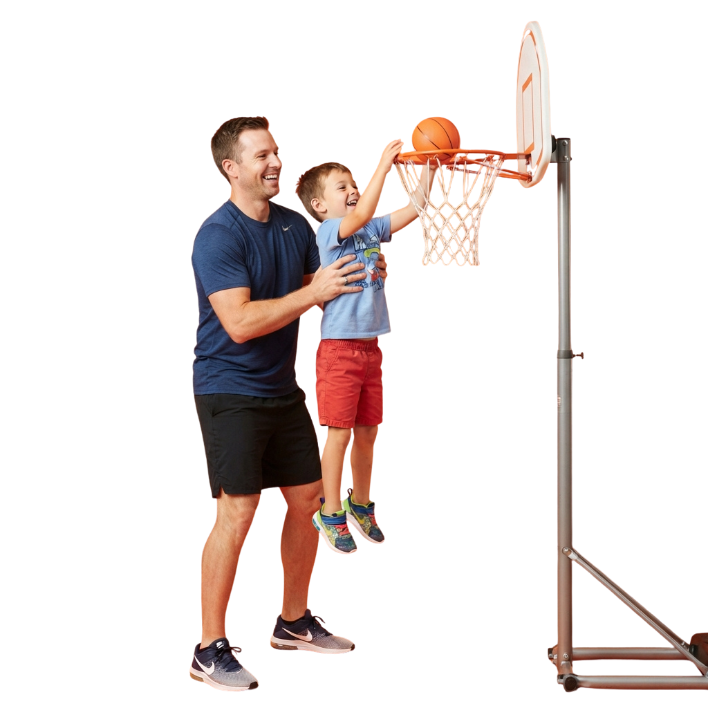 An adult helps a child shoot a basketball into a hoop with both of them smiling and enjoying the activity.