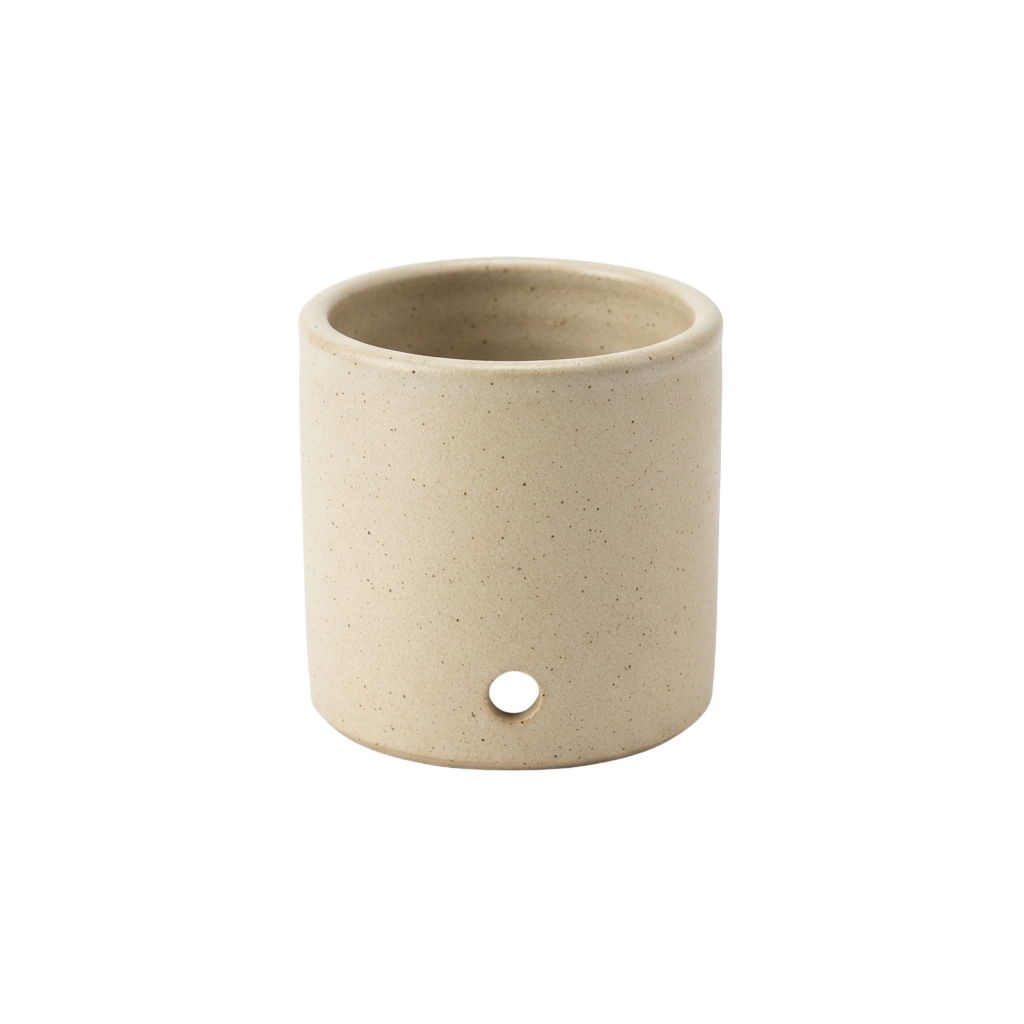 A simple beige ceramic candle holder with a small drain hole at the bottom
