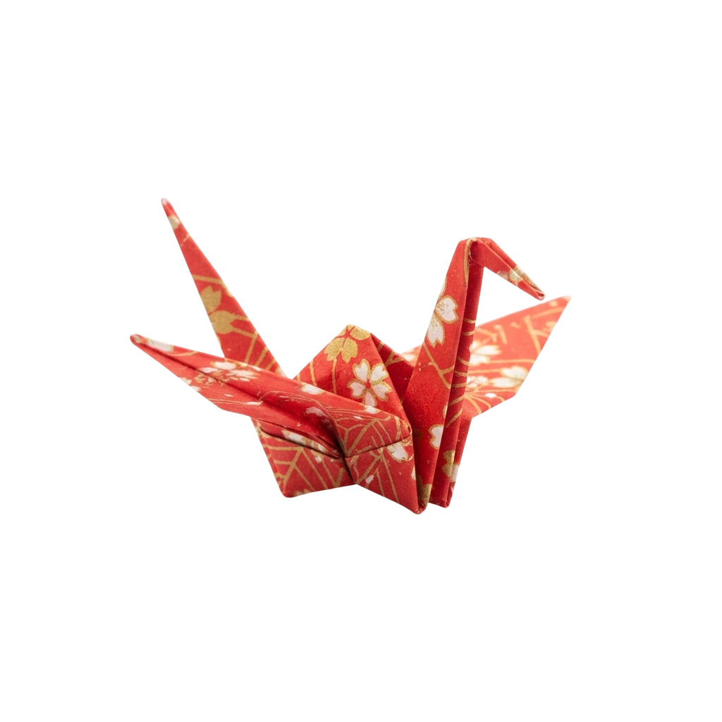 A red origami paper crane with white floral patterns displayed against a black background