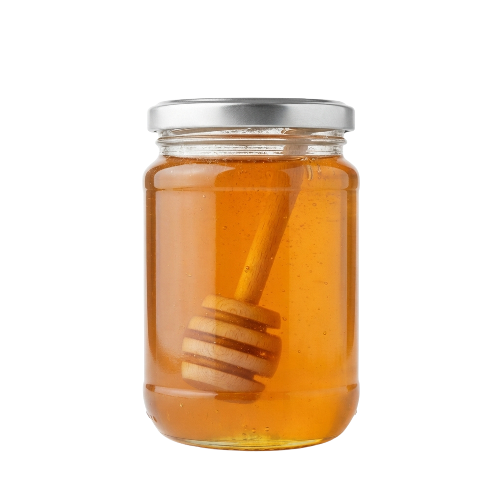 A glass jar filled with golden honey and a wooden honey dipper inside