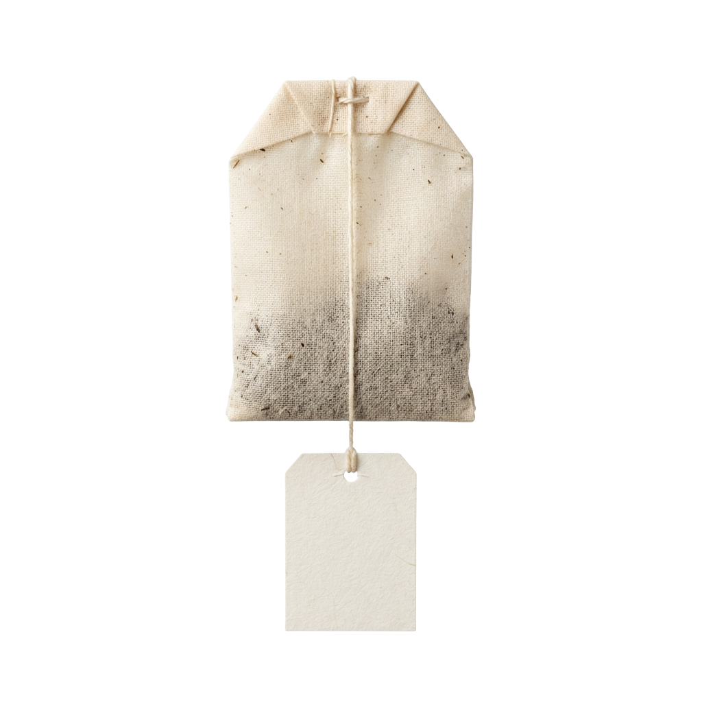 A used tea bag hanging from a small tag against a black background