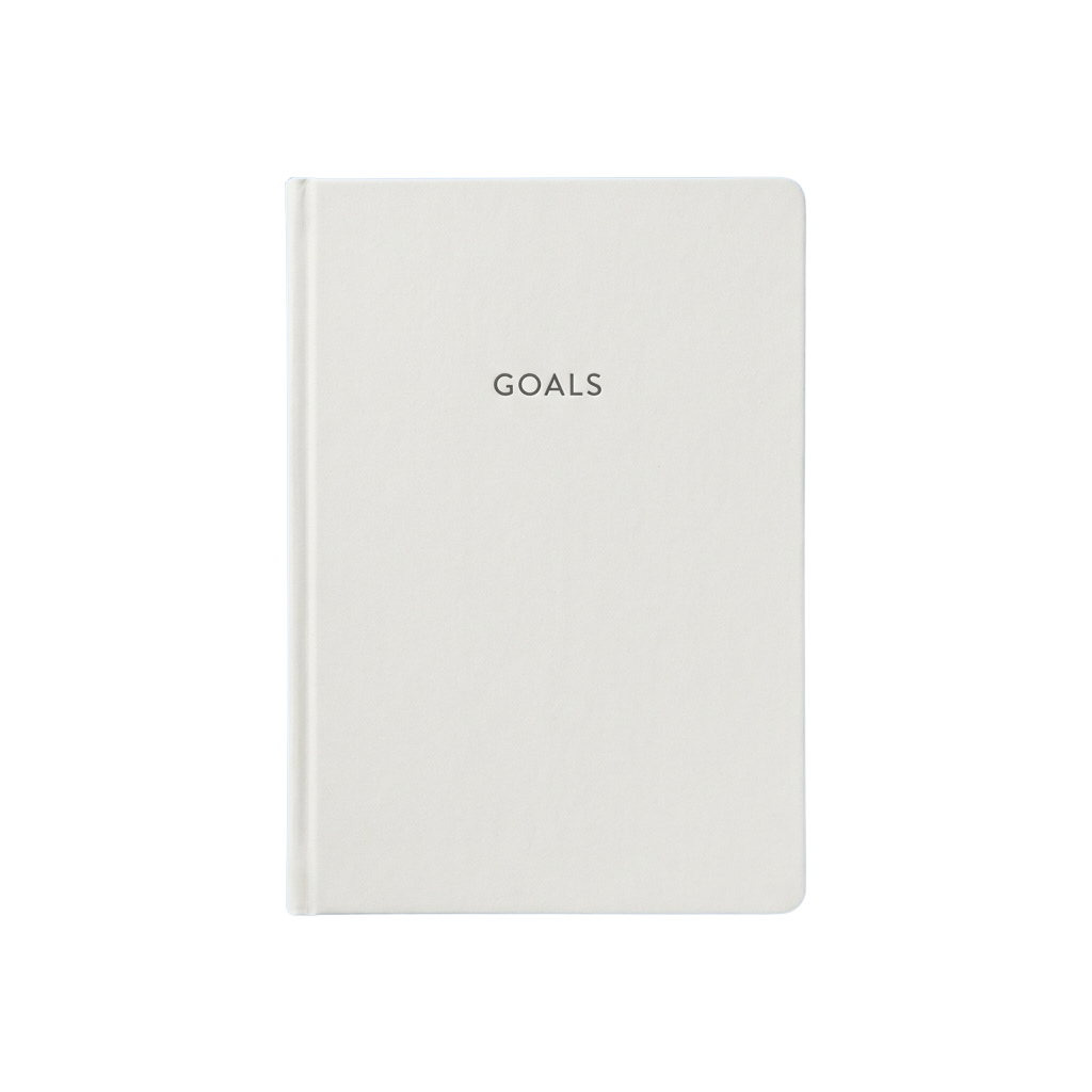 A white notebook with the word Goals embossed in gold lettering on the cover.
