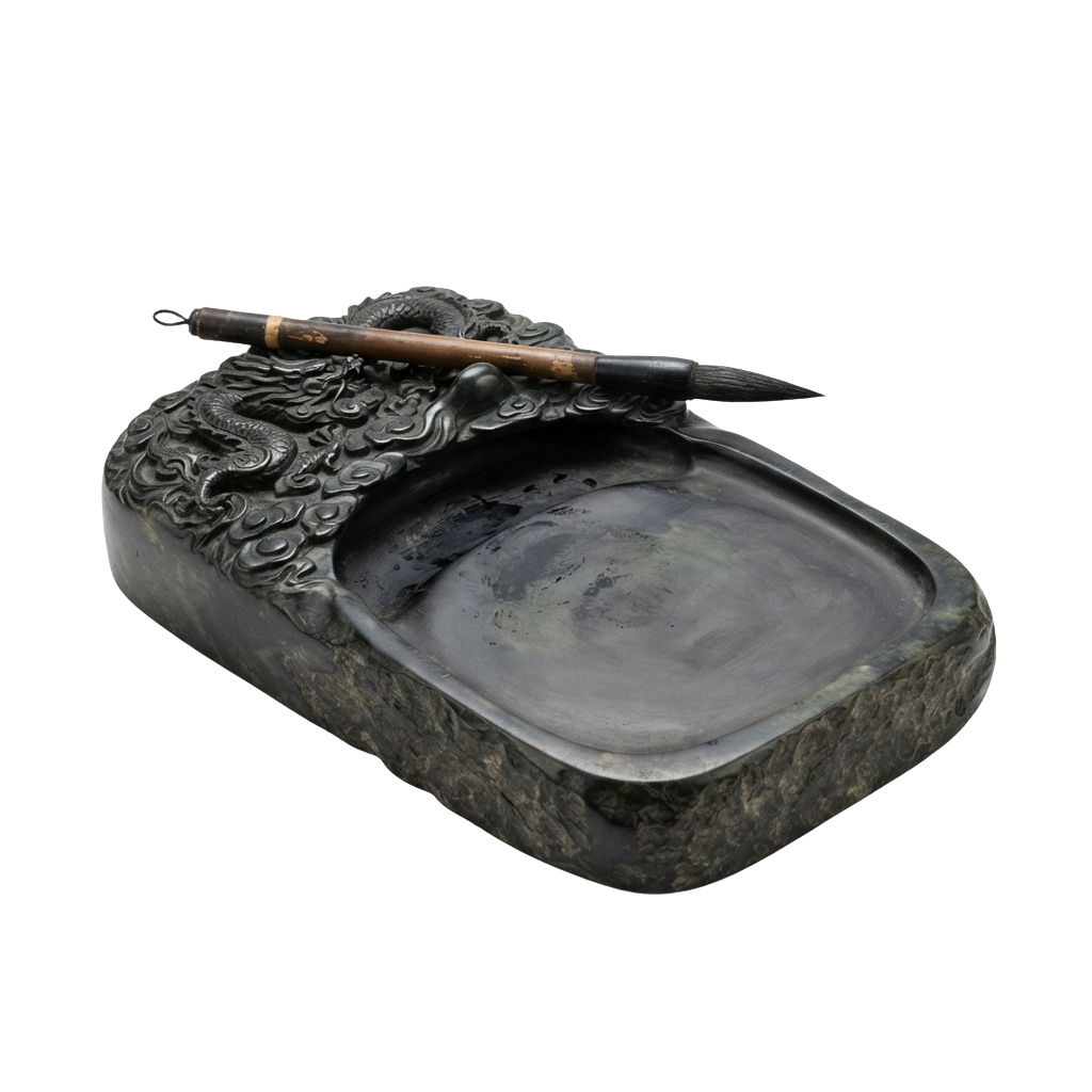 An intricately carved stone ink slab with a dragon motif and a matching brush resting on top