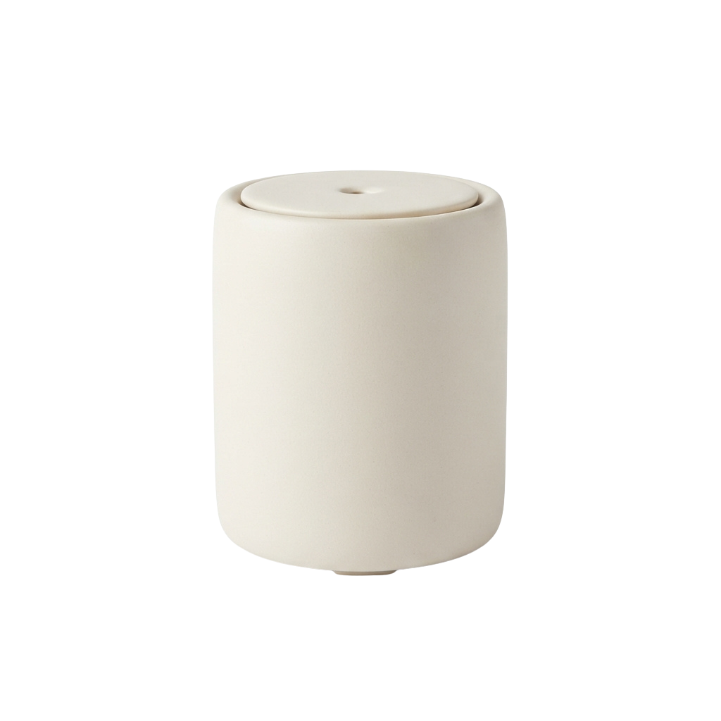 A sleek white cylindrical ceramic object with a smooth lid on a black background