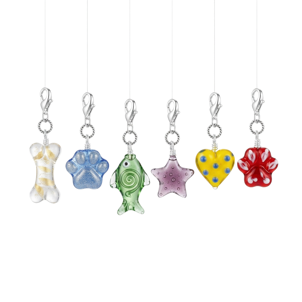 Five colorful glass bead charms hanging on silver loops against a black background
