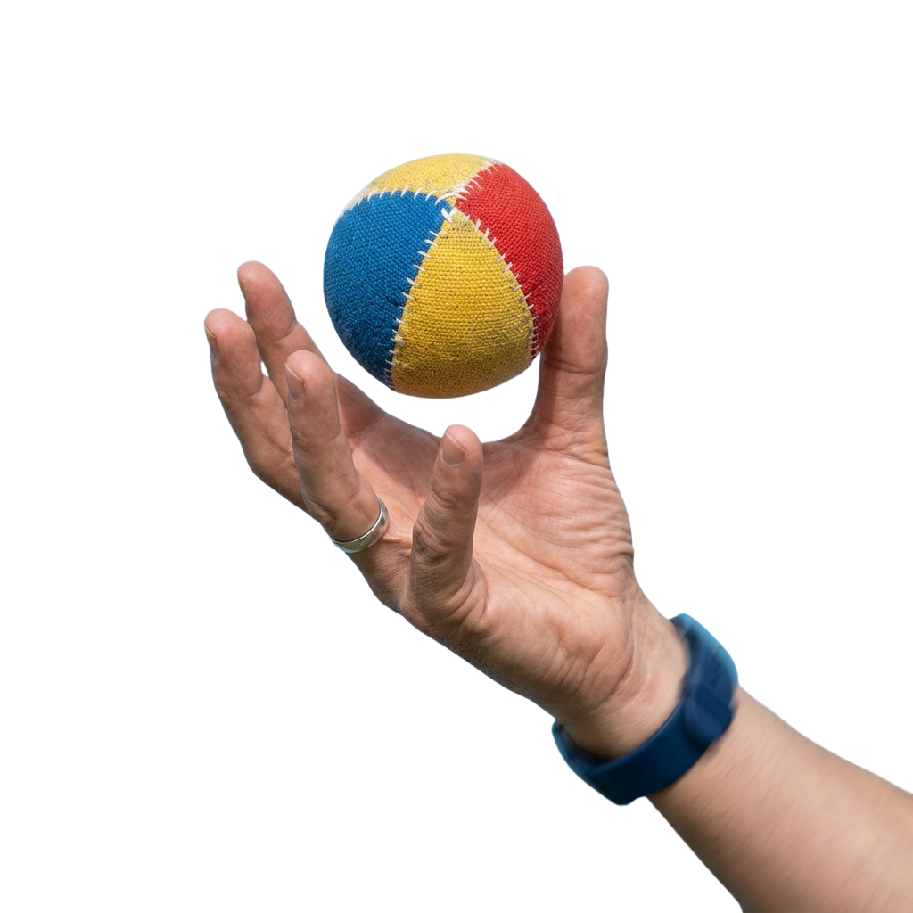 A hand holding a multicolored ball with blue, yellow, and red sections against a black background