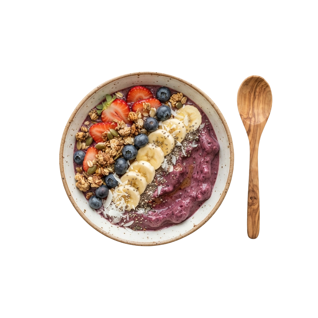 A bowl of purple oatmeal topped with sliced banana, blueberries, strawberries, granola, and seeds next to a wooden spoon.