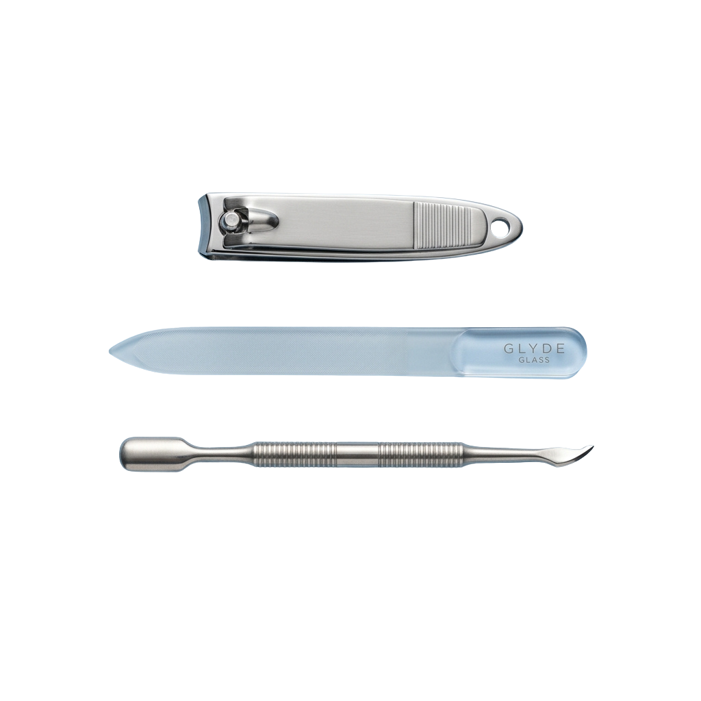 Three manicure tools: a stainless steel nail nipper, a clear glass nail file, and a metal cuticle pusher.