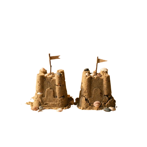 Two detailed sandcastles with small flags on top against a dark background