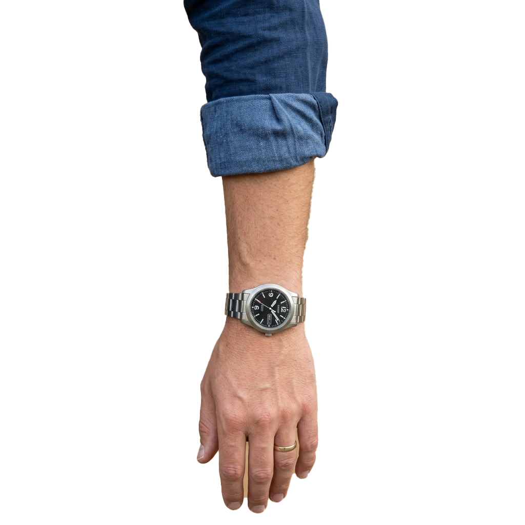 Person wearing a silver-toned wristwatch on their left wrist with a rolled-up denim sleeve