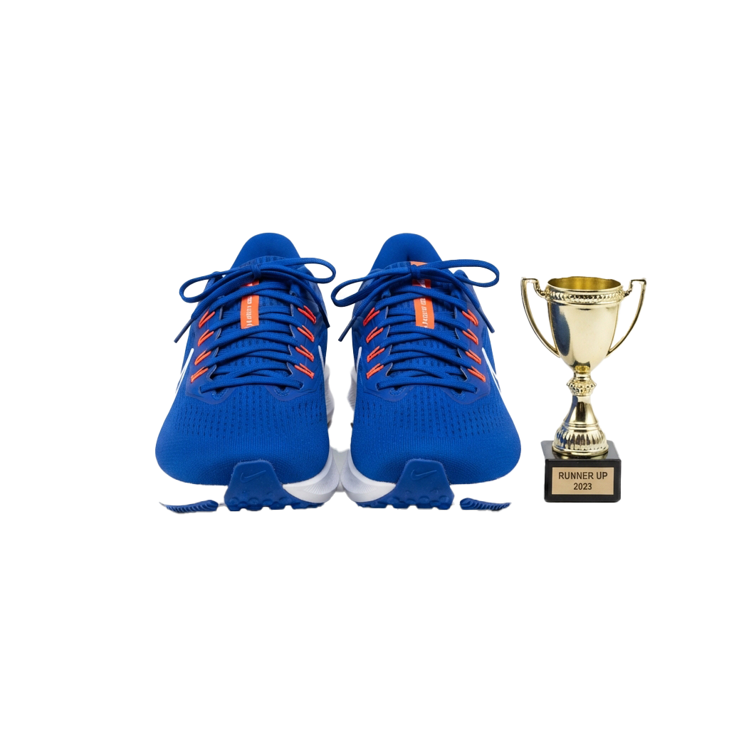 Blue athletic shoes with orange accents next to a runner-up trophy labeled 2023
