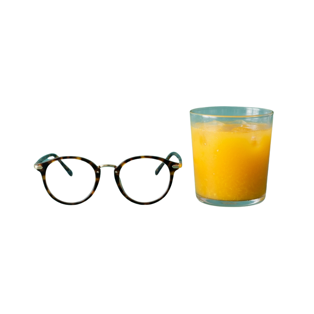Pair of round tortoiseshell glasses next to a glass filled with orange juice