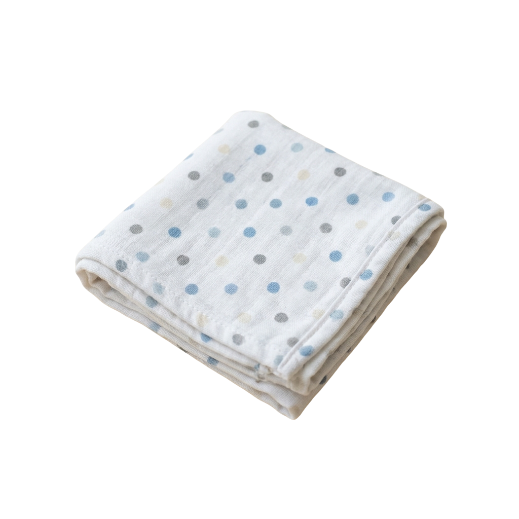 A folded white blanket with blue and gray polka dots