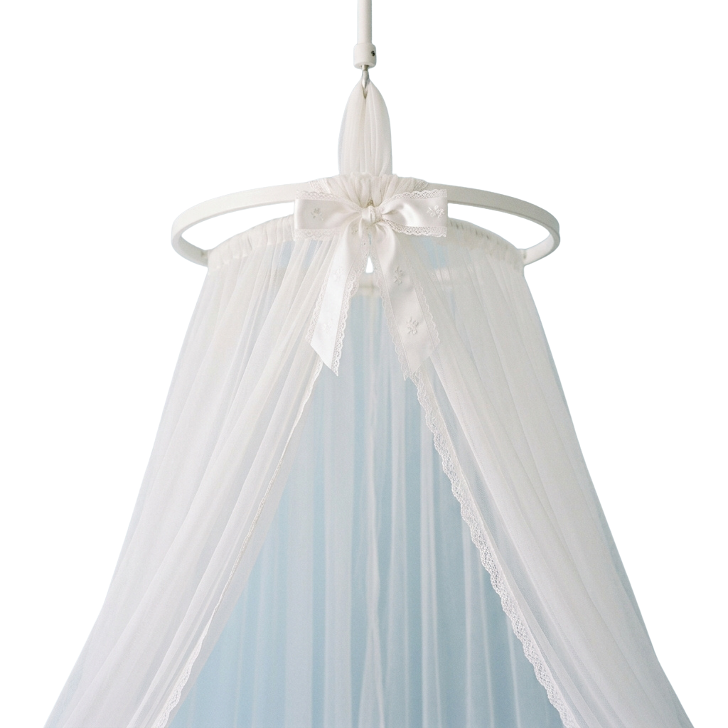 A white baby canopy with lace trim and a bow at the top
