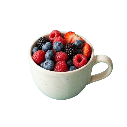 A white ceramic bowl with a handle filled with fresh raspberries, blackberries, and blueberries