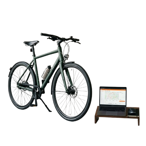 Electric bicycle next to a laptop on a small wooden stand against a black background