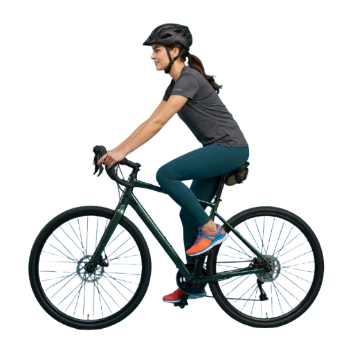 A person wearing a helmet rides a road bike in a dark setting, holding handlebars and wearing athletic clothing.