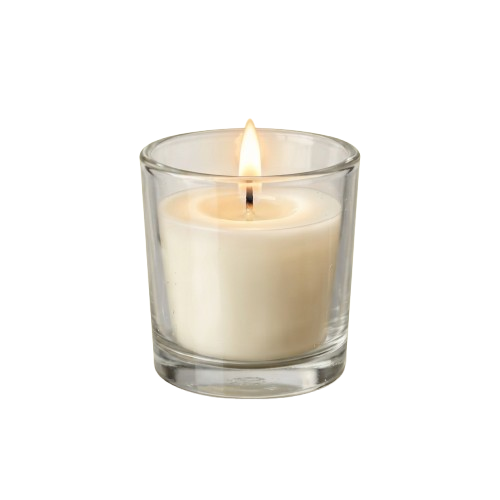 A lit candle in a clear glass container with white wax burning softly