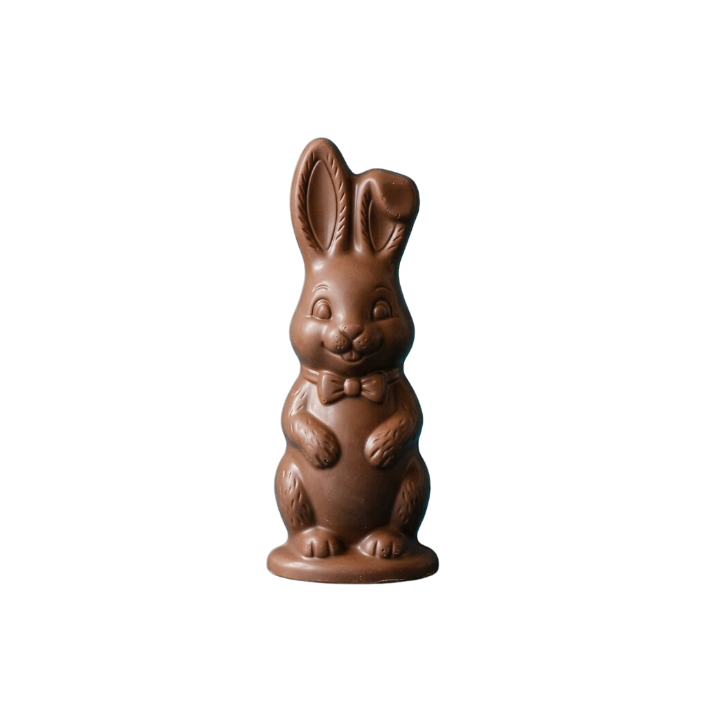 A brown chocolate bunny figurine wearing a bow tie standing upright against a dark background
