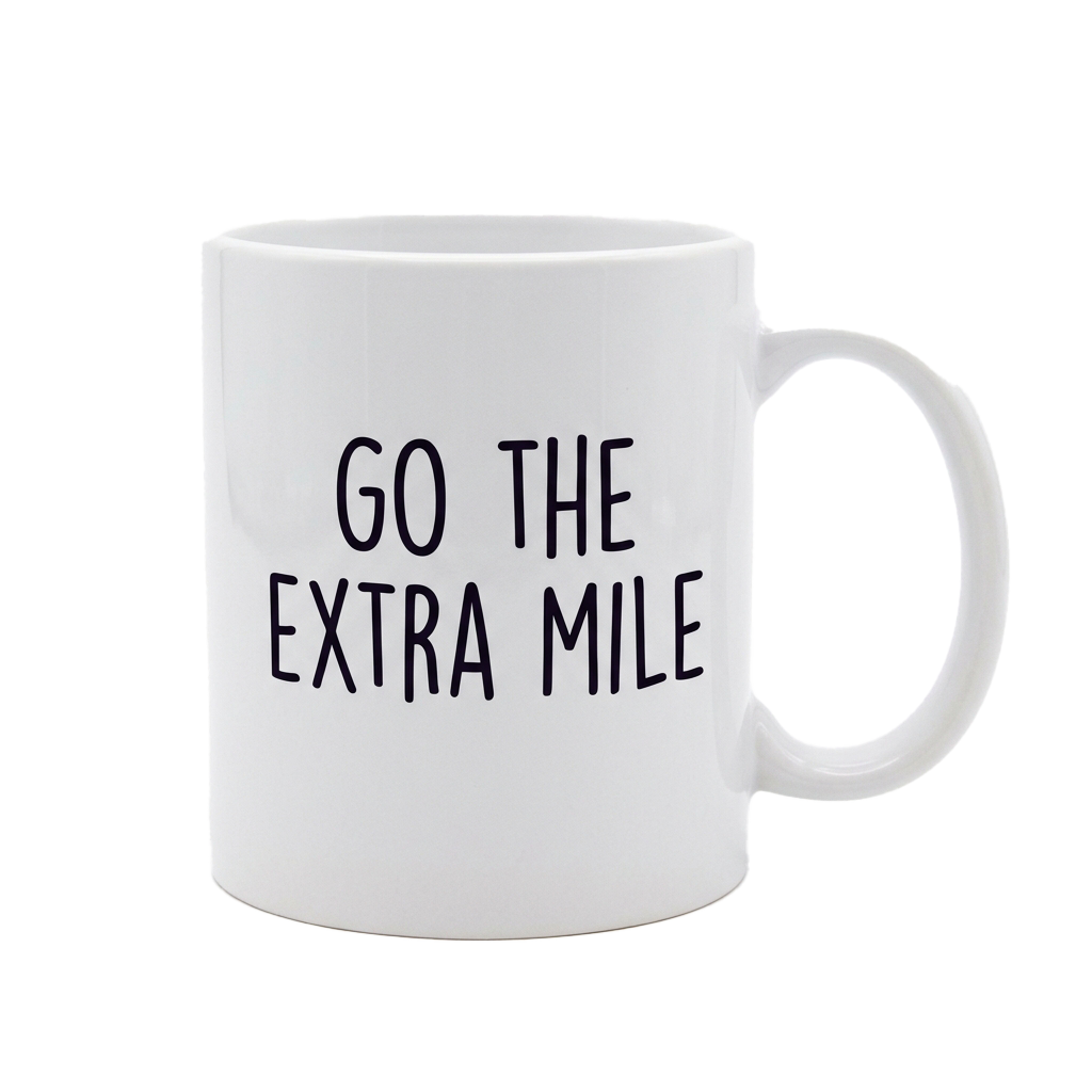White mug with black text reading Go the Extra Mile