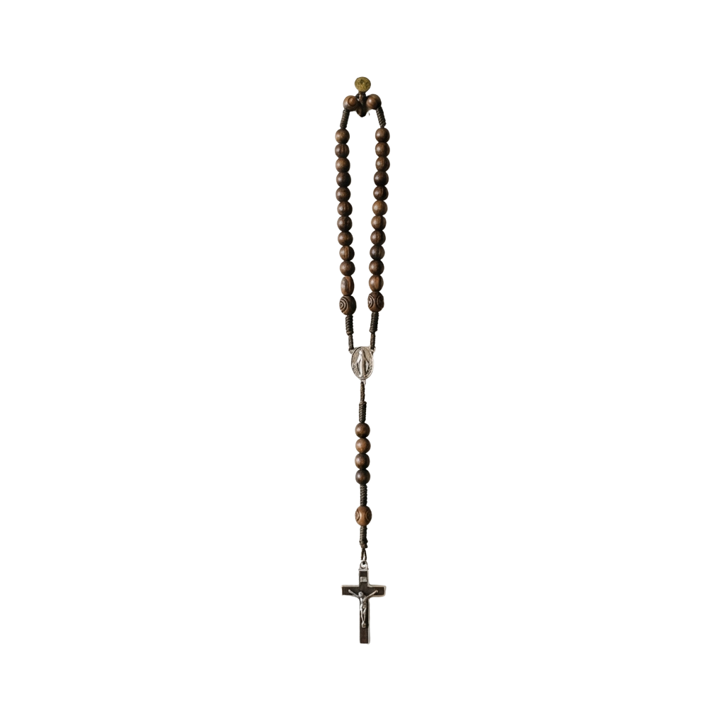 A wooden rosary with brown beads and a silver cross pendant hanging on a black background