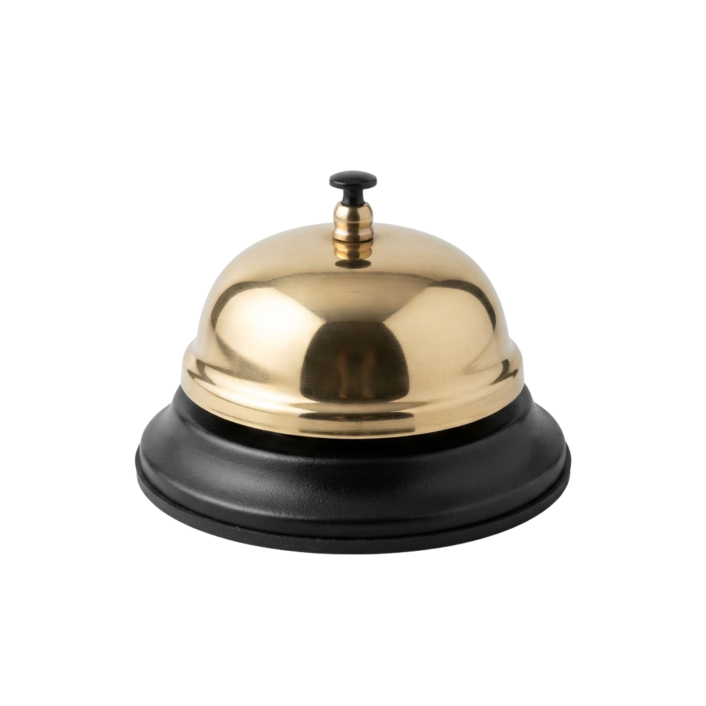 A polished gold-colored bell push on a black base, used for calling assistance at a reception desk