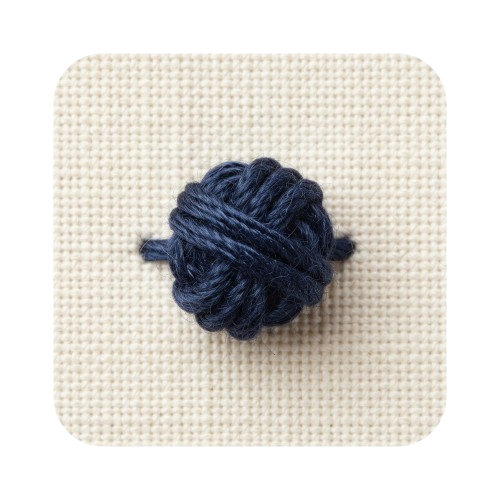 A small dark blue knotted yarn ball placed on a light beige woven fabric surface
