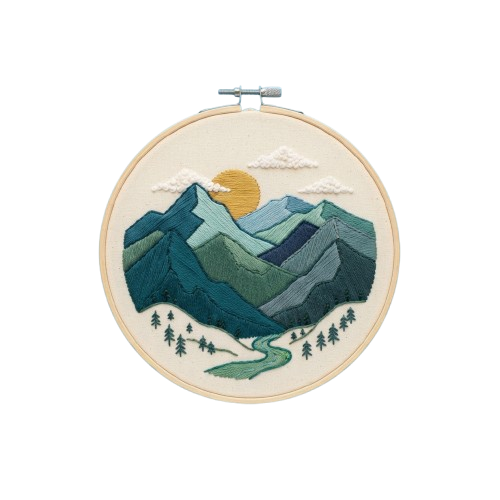 Circular embroidery hoop art depicting a mountain range with a sunset and winding path surrounded by trees