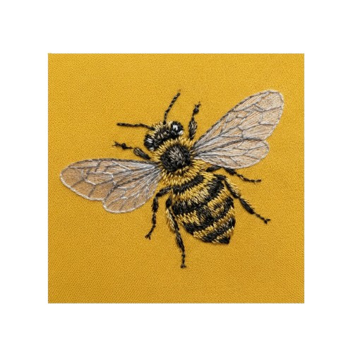 A detailed embroidery of a black and yellow bee on yellow fabric with transparent wings.