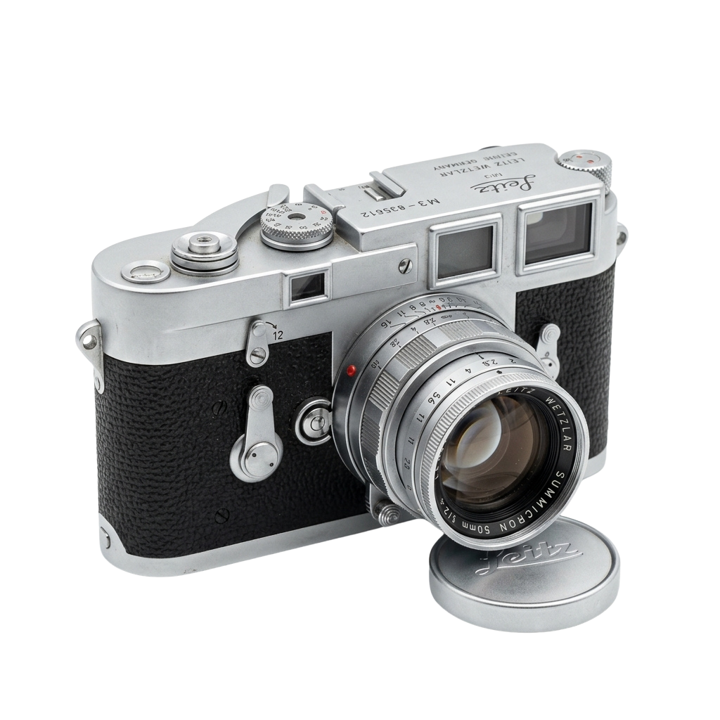 Classic silver and black rangefinder camera with a 50mm Summicron lens and a round metal accessory case
