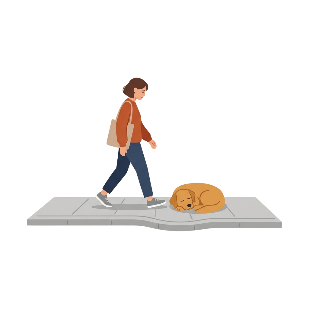 A person walking on a sidewalk while a dog sleeps on the ground nearby