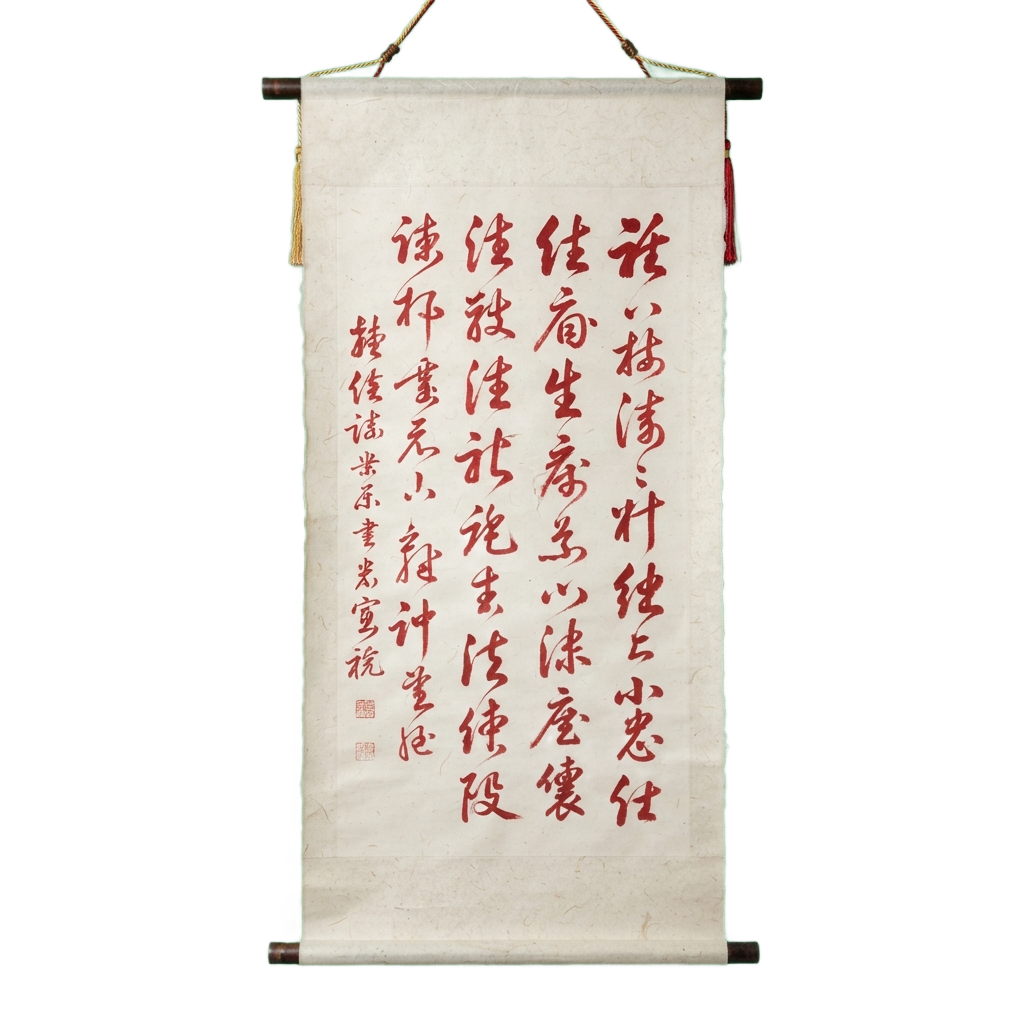 Vertical scroll with red Chinese calligraphy on light fabric background, hanging with green and brown cords