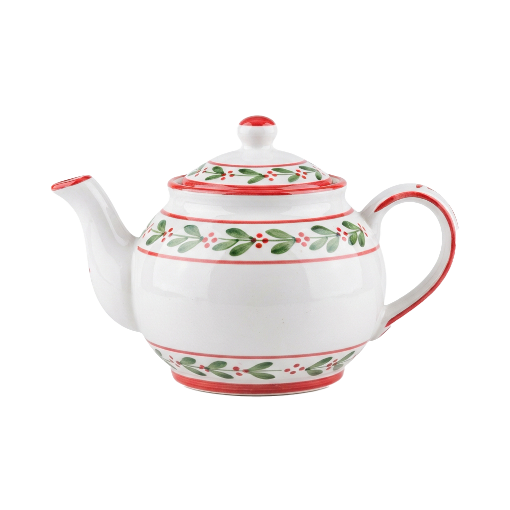 White teapot with red trim and green holly leaf patterns on lid and body