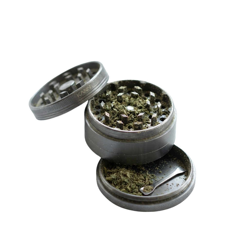 Open metal herb grinder with a scoop, showing ground plant material inside.