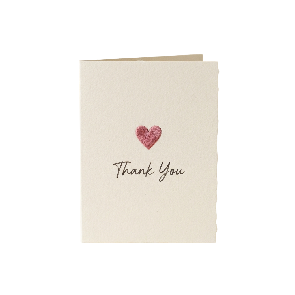 A cream-colored thank you card featuring a small red heart and handwritten thank you text