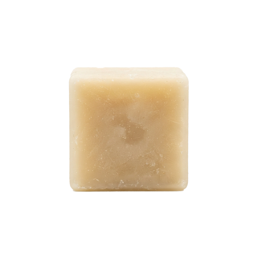 A close-up image of a single beige square bar of soap with a textured surface