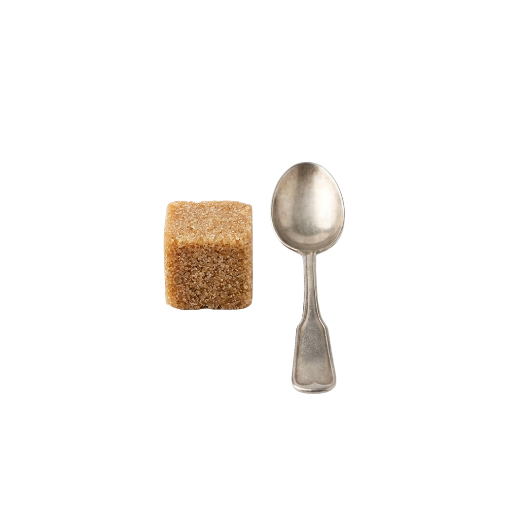 A single sugar cube next to a small silver teaspoon on a black background