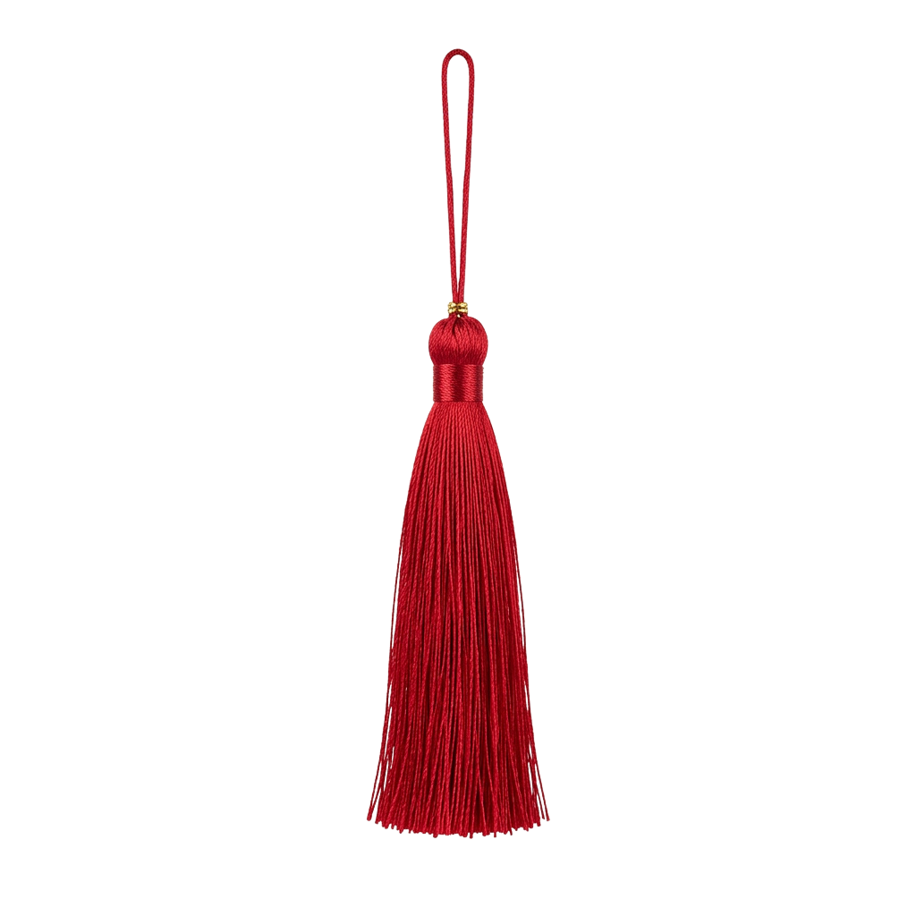 A bright red velvet tassel attached to a metallic keyring against a black background