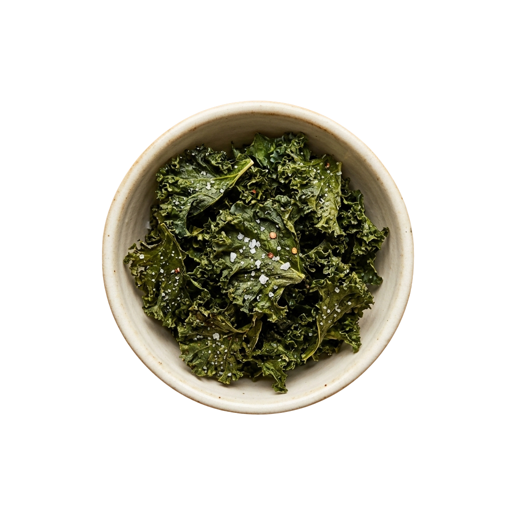A white bowl filled with crispy green kale chips sprinkled with seasoning