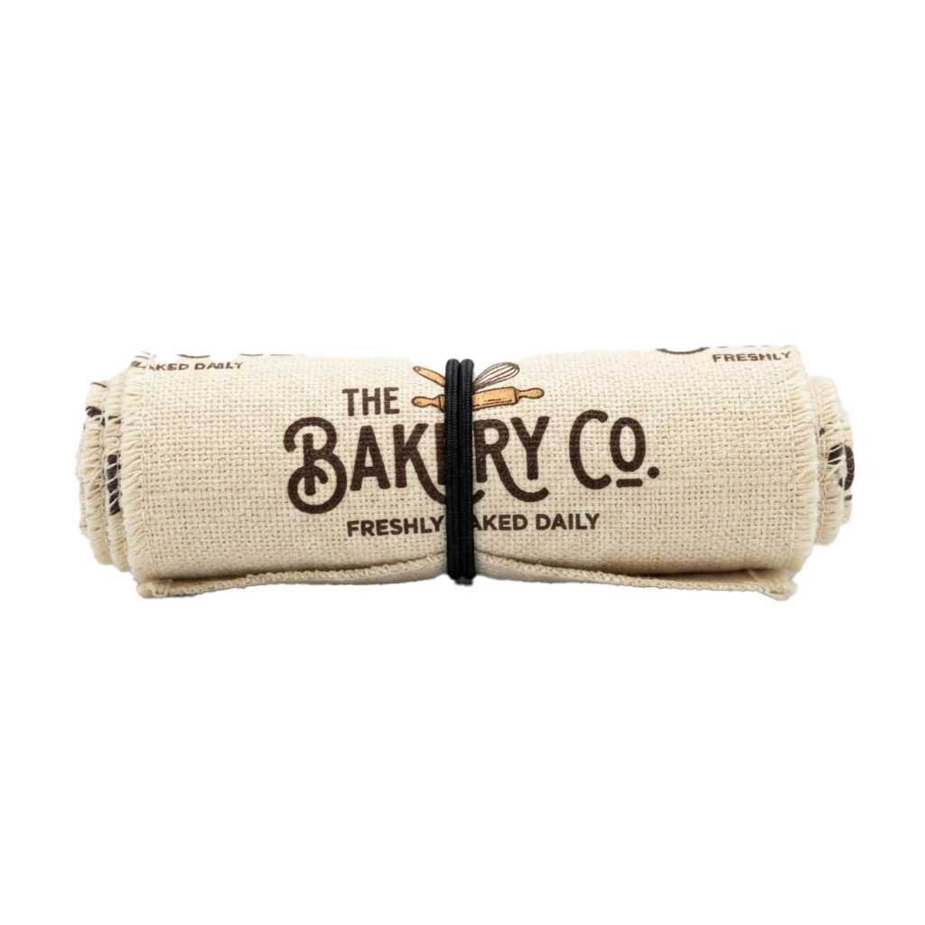Fabric napkin roll with Bakery Co branding and freshly baked daily text