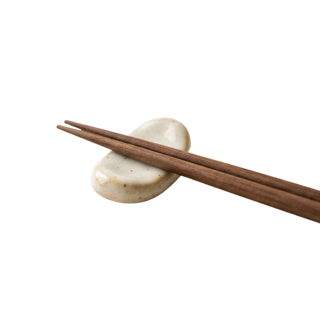 A pair of wooden chopsticks lifting a soft, round, white steamed bun against a dark background