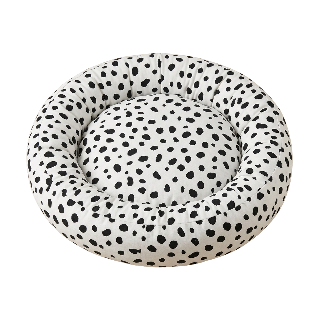 Round pet bed with black and white polka dot fabric covering